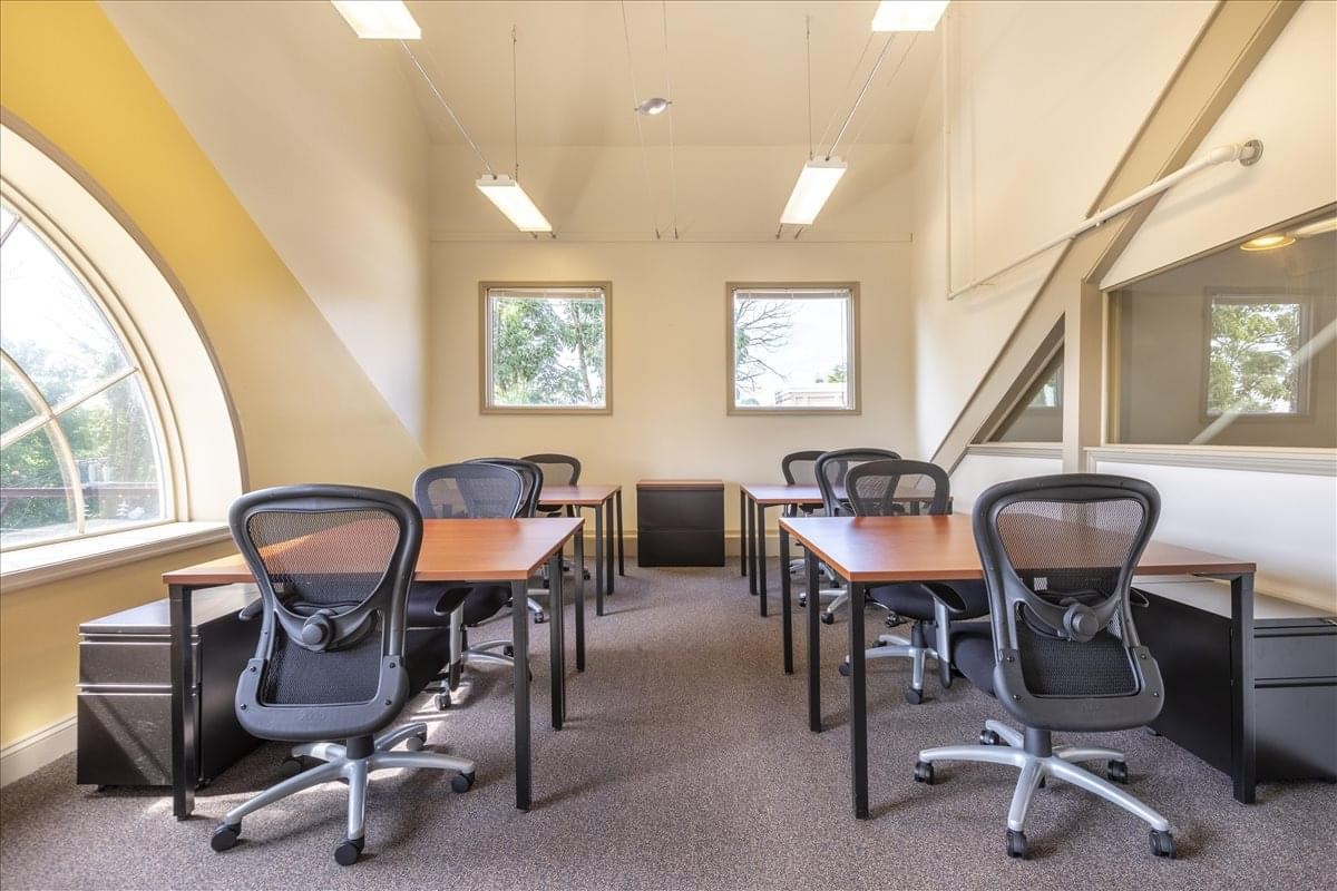 Open-plan office space at 196 West Ashland Street, 3rd Floor, showing desks and a distinctive arched window.