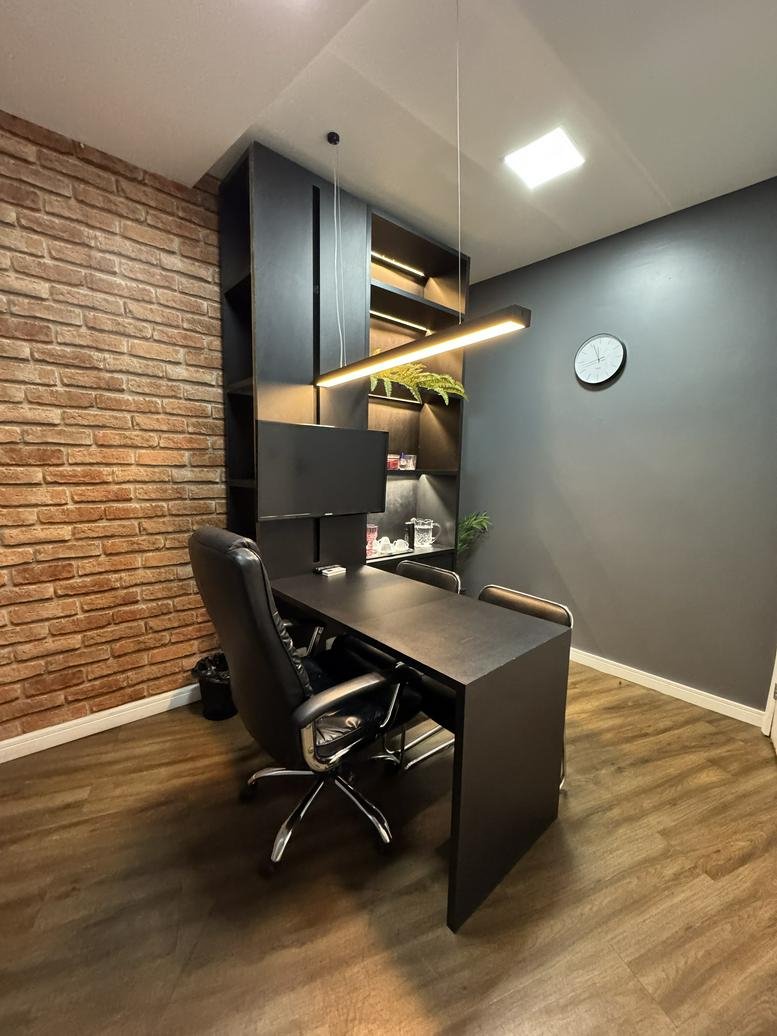 Modern private office at Shopping Seaway with a brick feature wall and dark wood desk.