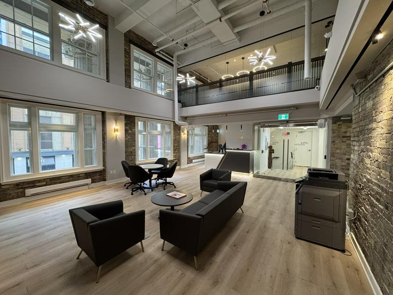 Open-concept lobby with leather sofas, large windows, and a lofted upper level.