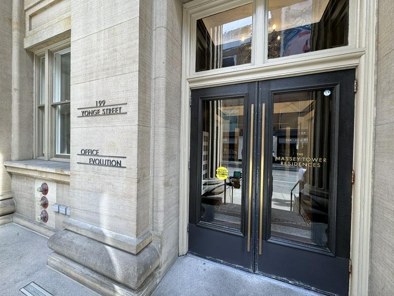 Exterior entrance of Office Evolution at 197 Yonge Street featuring dark wood-framed glass doors.