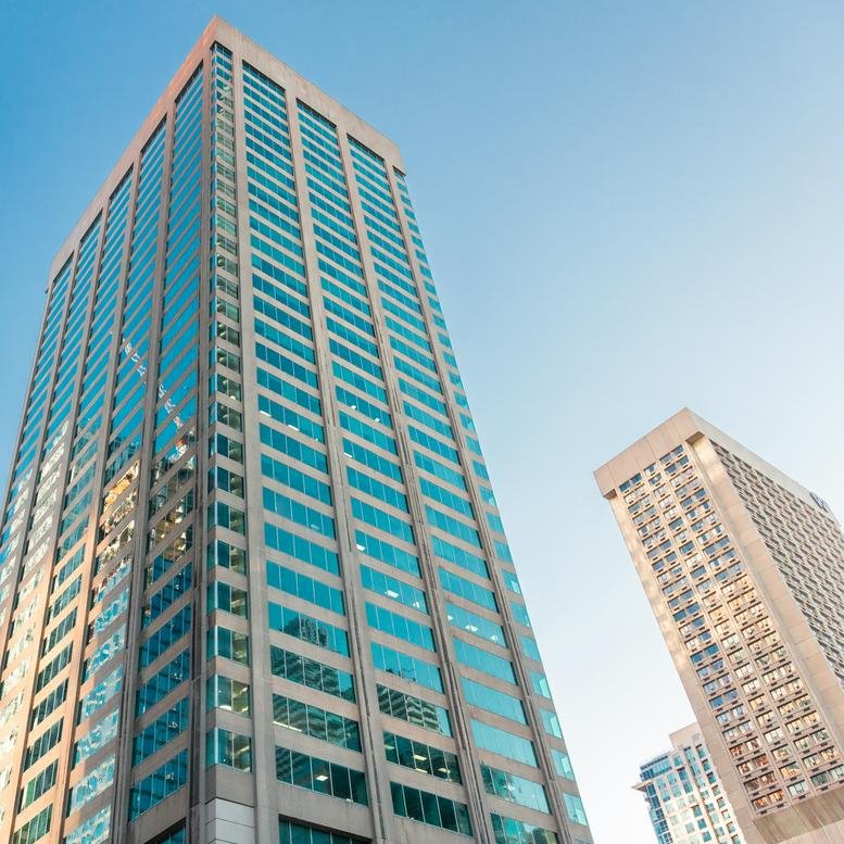 Wide exterior shot of the high-rise office towers against a clear blue sky.