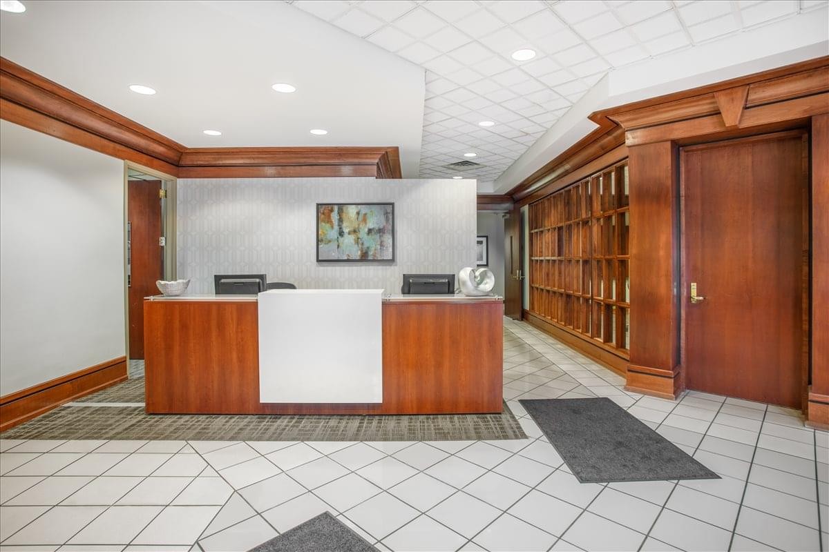 Reception area at 200 Prosperity Drive with a wood-fronted desk and expansive wood-paneled walls.