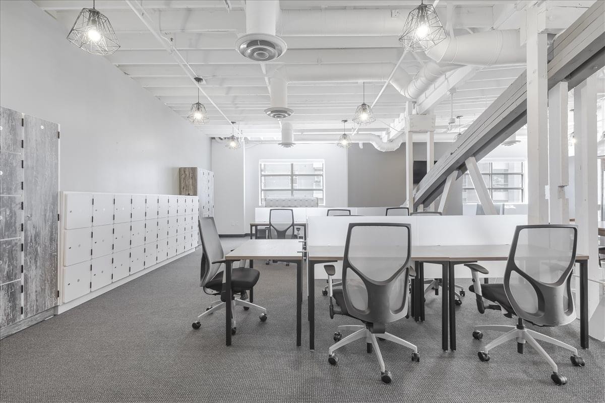 Modern coworking area at 201 North Brand Boulevard with industrial ceilings and personal lockers.