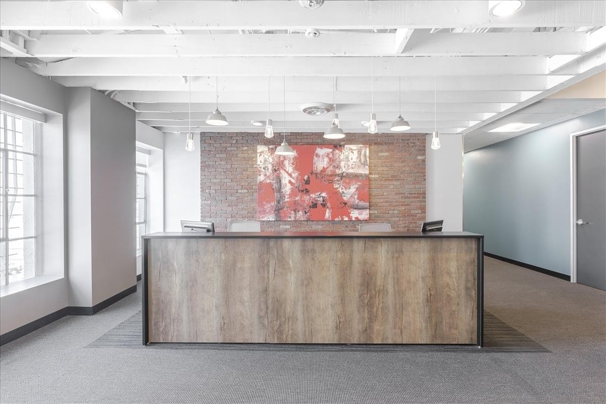 Reception desk at 201 North Brand Boulevard, Suite 200 featuring wood textures and a brick feature wall.
