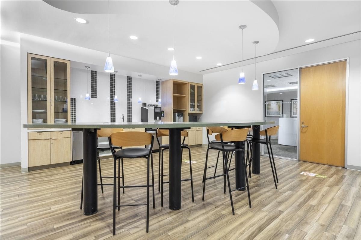 Modern communal kitchen at Miami Center with a high-top breakfast bar and wood flooring.
