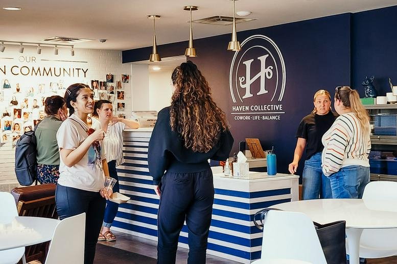 Modern reception area at Haven Collective with a striped front desk and navy branded wall.