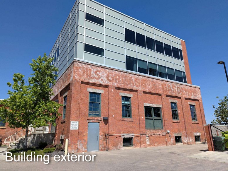 Exterior view of the brick and glass Snowdon Block building under a clear blue sky.