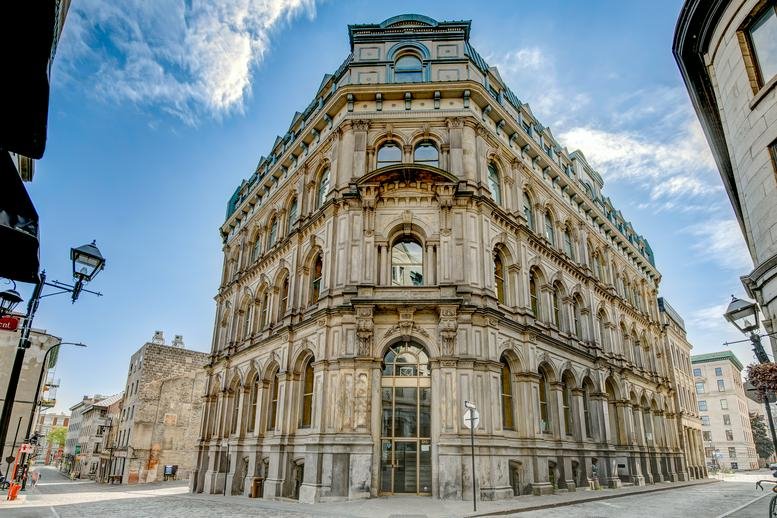 Ornate historic facade of 204 Rue du Saint-Sacrement with stone carvings and arched windows.