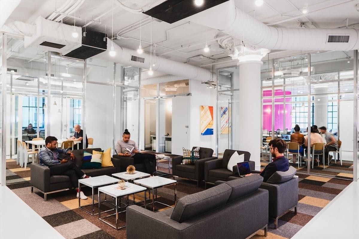Spacious communal lounge at 21 S 11th St with dark grey sofas and white coffee tables.