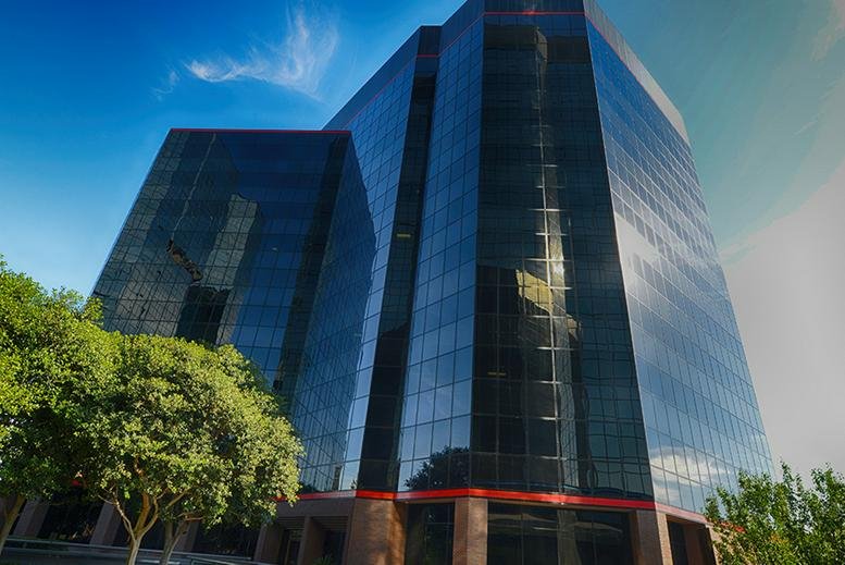 Exterior view of the glass-facade Warner Center Towers against a blue sky.