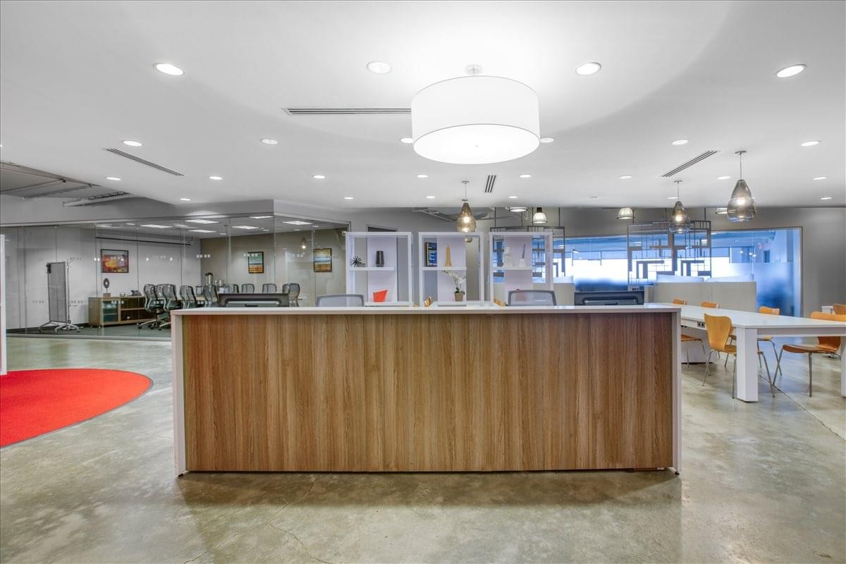 Spacious reception area featuring a wood-paneled front desk and polished concrete floors.