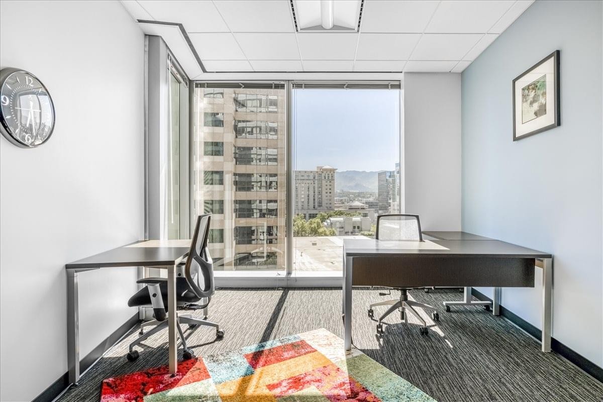 Private office at 222 Main Street with two desks and a scenic city view through large windows.