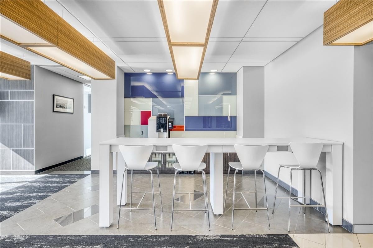 Modern breakroom at 222 Main Street featuring a white high-top table and colorful backsplash.
