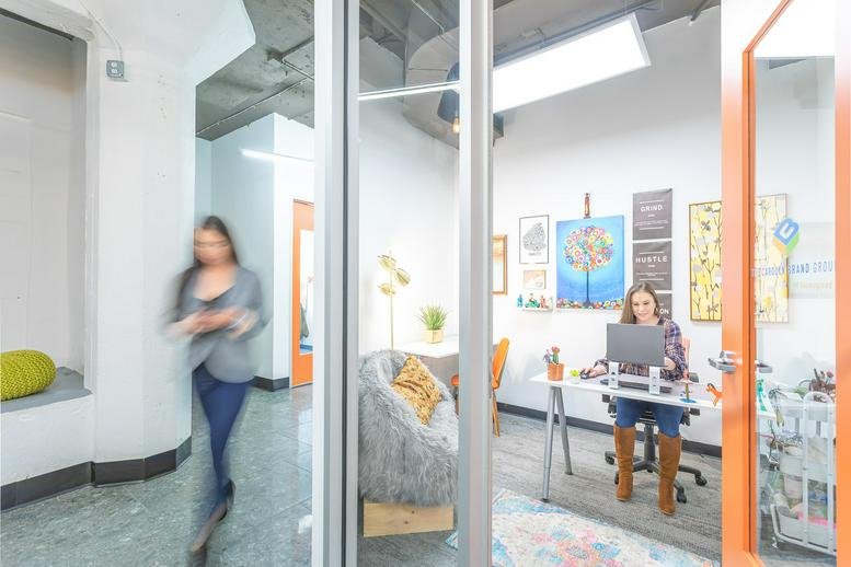 Bright internal office suite with artwork on the walls and an orange door frame.