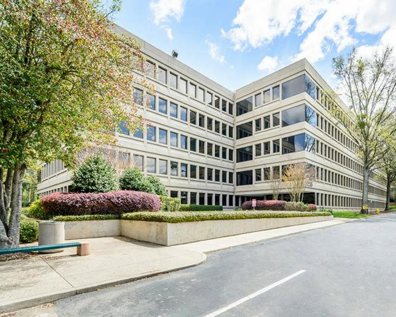 Exterior wide shot of the multi-story office building with landscaped gardens.