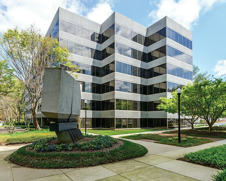 Exterior view of the multi-story glass and stone building at 2302 Parklake Drive.