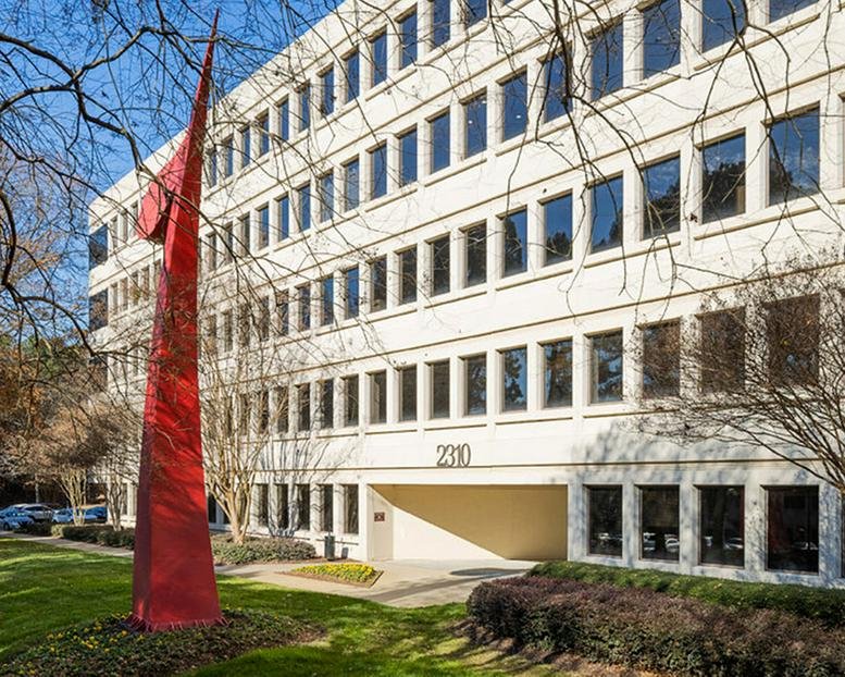 Exterior view of the office building at 2310 Parklake Drive featuring a large red modern sculpture.