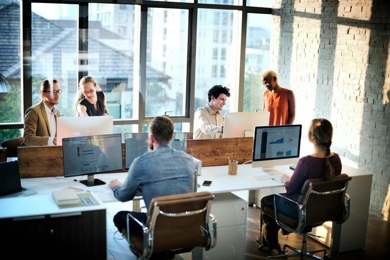 Bright, modern open-plan office with teams working at desks under natural light at 2385 Executive Center Drive.