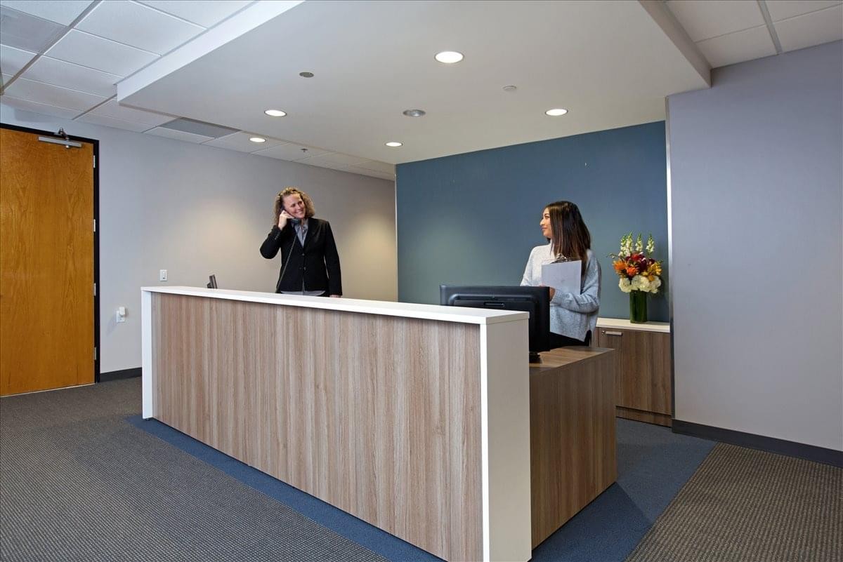 Professional reception area of the 2447 Pacific Coast Highway, 2nd Floor office with a wood-fronted desk.