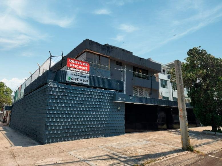 Exterior view of the dark grey Business Center, Colonia Providencia, Guadalajara building with a rental sign.