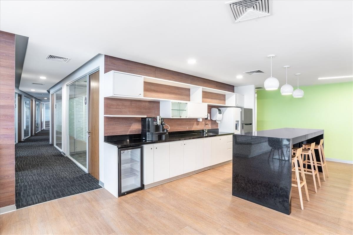 Modern kitchen and break area at 254 El Derby Avenue, Suite 2501 with a black marble island.