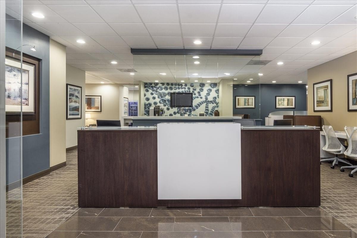 Professional reception area for 2700 Corporate Drive, Suite 200, with a dark wood front desk.