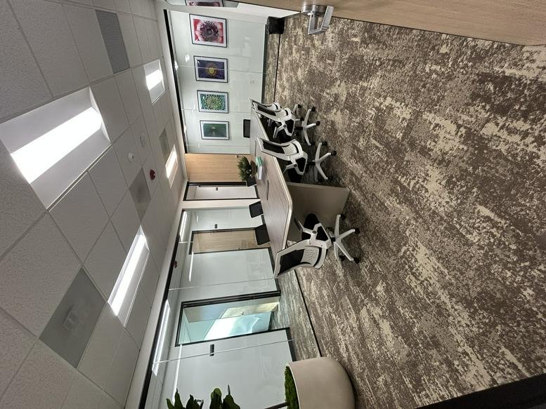 Long conference table with modern ergonomic chairs and abstract wall art.