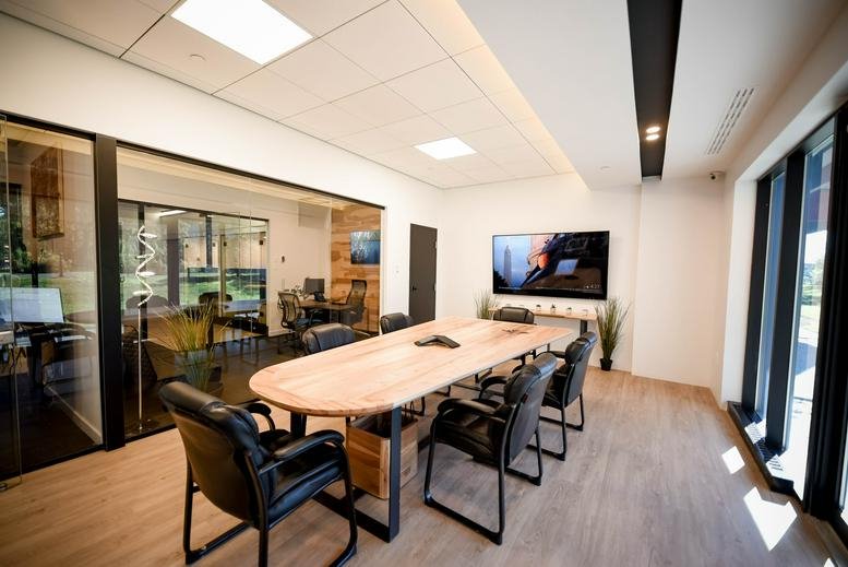 Spacious boardroom with a large light wood table and leather chairs at 2727 Coworking, Rue Saint-Patrick, Montreal.