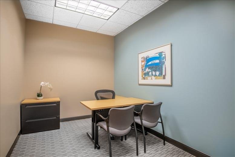Small meeting room with blue accent wall and a framed picture.