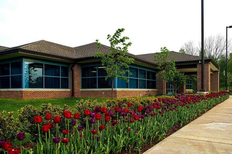 Exterior view of the brick facade and tulip gardens at 28175 Haggerty Road.
