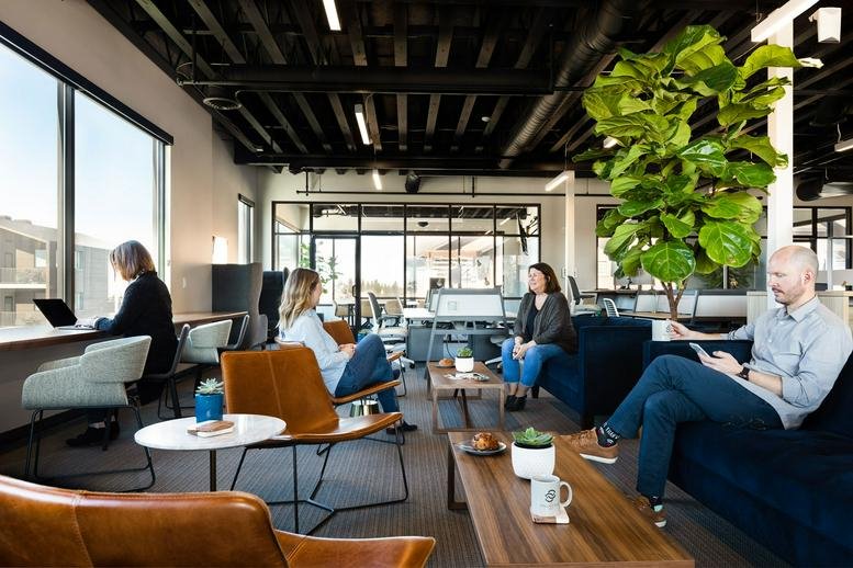 Bright, spacious coworking lounge at Work-Collective, 2900 NW Clearwater Dr, Bend featuring plants and plush seating.