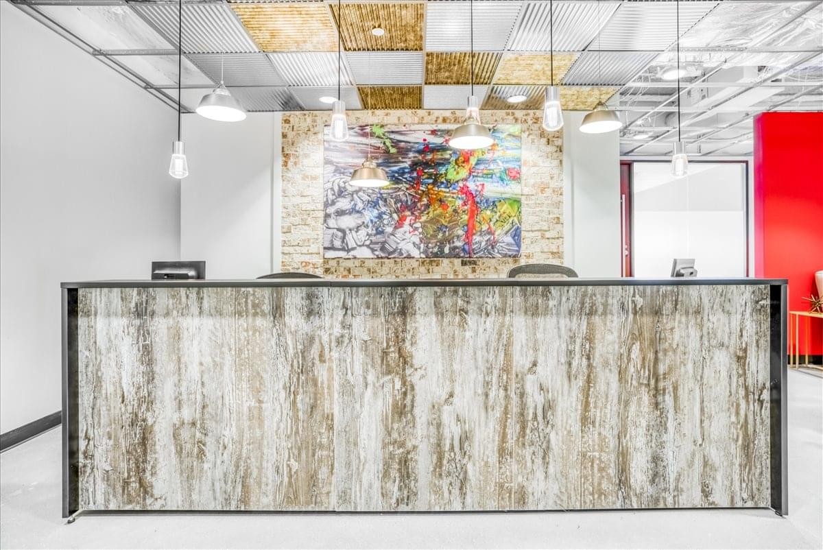 Modern reception area at CIRA Centre featuring a textured wood-look desk and vibrant abstract wall art.