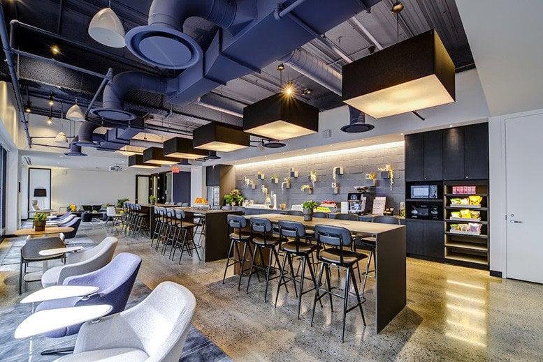 Spacious breakroom at 30 South 17th Street with high-top seating and colorful modern lighting.