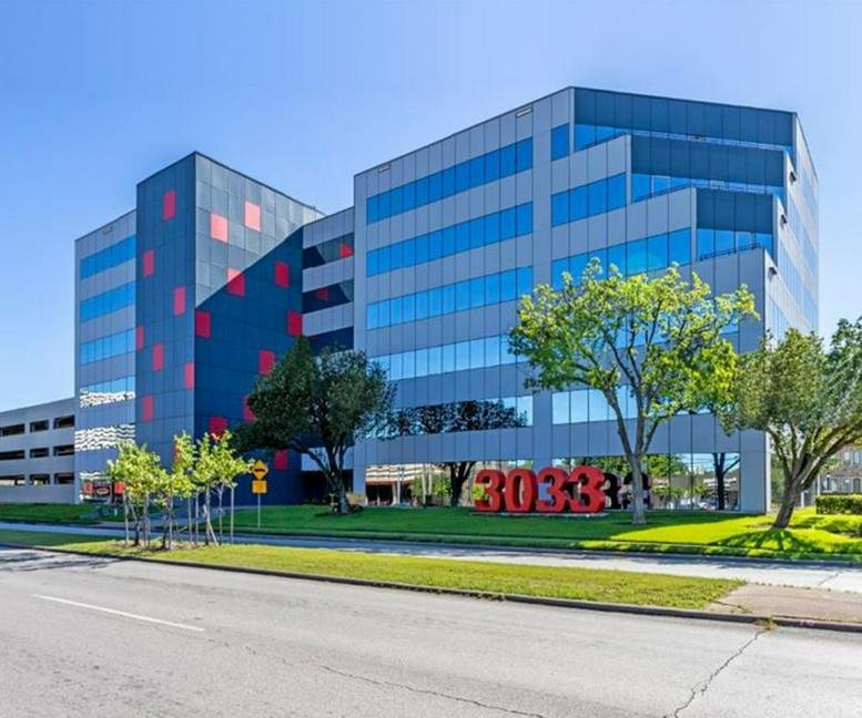 Exterior facade of the 3033 Chimney Rock building with blue glass and red accents.