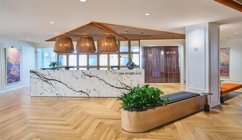 Reception area at 3033 Wilson Boulevard with a marble desk and herringbone wood floors.