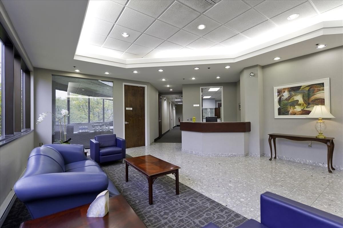 Spacious reception area with a wooden front desk and blue seating area.