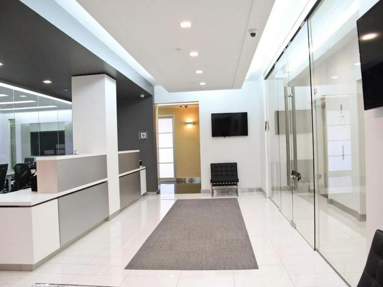 Bright, modern lobby at 31 West 34th Street with a white reception desk and glass walls.