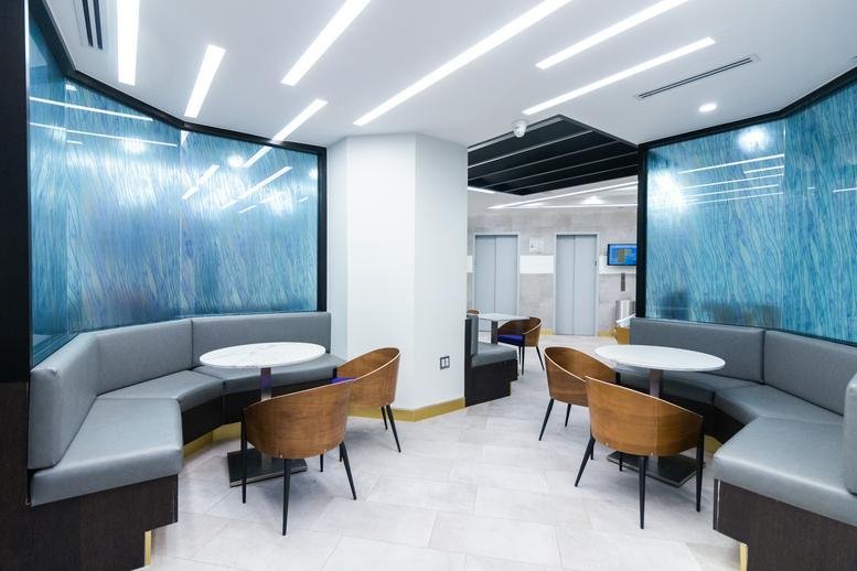 Modern breakout area at 31 West 34th Street with curved grey seating and blue feature walls.