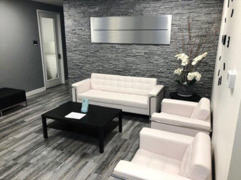 Modern lobby at 3175 E. Warm Springs Rd featuring a stone accent wall and white leather seating.