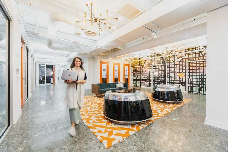 Spacious reception area with decorative chandelier and bold patterned rug.