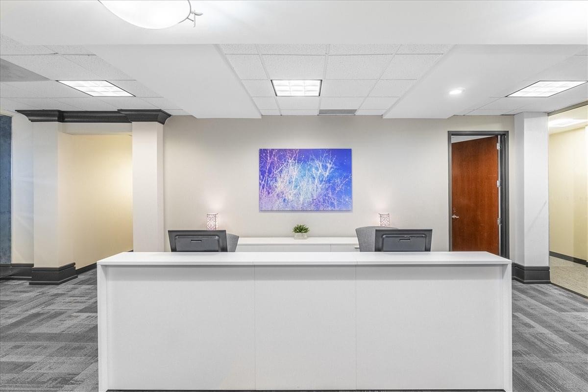 Lobby area of 3235 Satellite Blvd., Suite 300, Building 400 featuring a white reception desk and purple art.