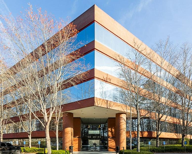 Angular exterior facade of the brick and glass office building at 3295 River Exchange Drive.