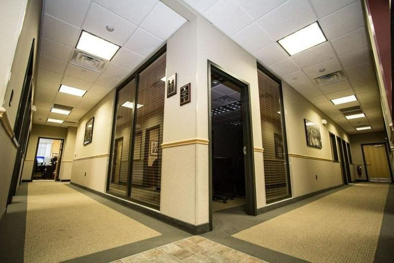 A modern corner office hallway with glass-walled suites at 330 Changebridge Road.