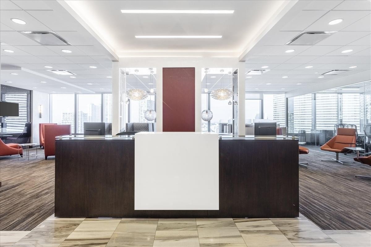 Modern reception area at Wells Fargo Center featuring a dark wood desk and bright white accents.