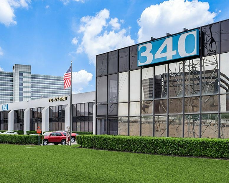 Exterior facade of 340-350 N Sam Houston Pkwy E under a bright blue sky.