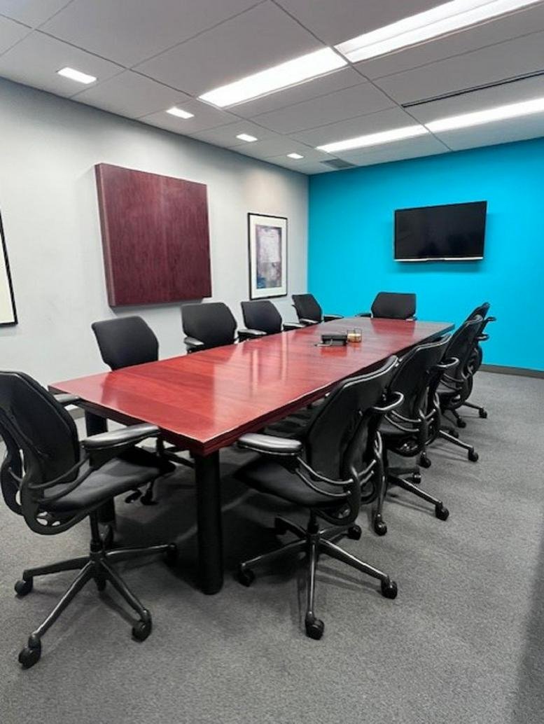 Meeting room at Enterprise Place with a large wooden table and bright blue feature wall.
