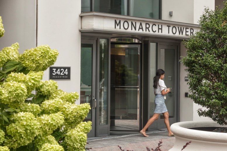 Exterior entrance of Monarch Tower at 3424 Peachtree Rd featuring glass revolving doors.