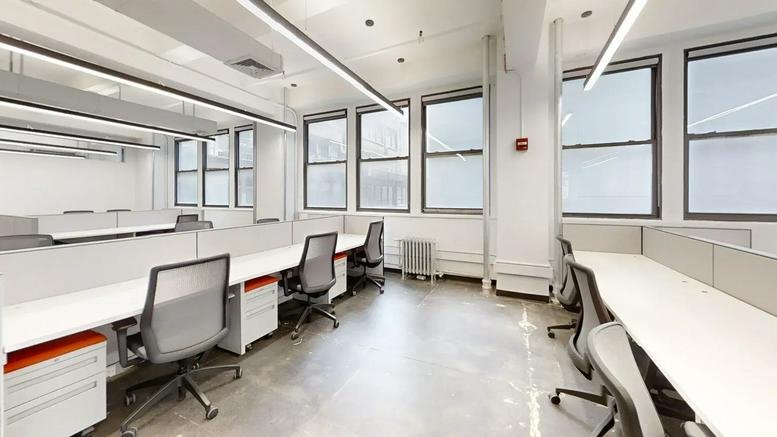 Spacious open-plan workspace at 345 7th Avenue with rows of desks and large windows.