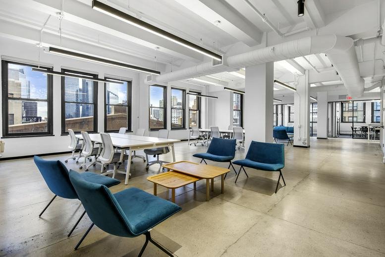 Bright coworking lounge at 345 7th Avenue, Floor 20 with blue velvet armchairs and wooden coffee tables.