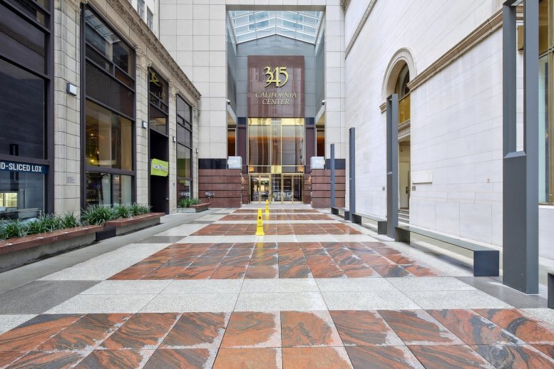 Polished stone courtyard leading to the golden entrance of 345 California Center.